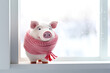 © Elena - Piggy bank with pink scarf on window background. Concept of heating season