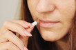 © Paweł Michałowski - White tablet between fingers. Woman taking medication. Health treatment or substance use background. Painkiller in hand with open mouth. Medical dose or addiction concern.
