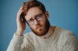 © Ева Поликарпова - A man with a beard and glasses holding his head, possibly in frustration or concern