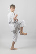 © Ben Gingell - Fifteen year old male teenage karate black belt doing a side kick, studio shot against a white background