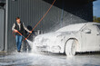 © Serhii - Car wash equipment. A man is washing a car at self service car wash. High pressure vehicle washer machine sprays foam