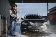 © Serhii - Car wash. Man washes car with water from high pressure washer