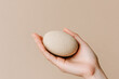 © perfectlab - Hand holding a natural stone in minimalist setting