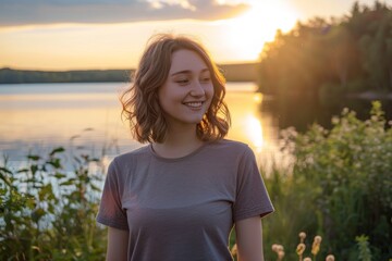 Canvas Print - Portrait of a happy woman in her 20s dressed in a casual t-shirt over serene lakeside view