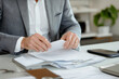 © Level UP - Busy Hands Organizing Documents on a Neat Desk with Soft Background Focus