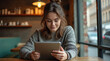 © Oleksandr - woman with a tablet in a cafe working remotely