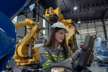 Engineer standing by robotic arm and operating machine in industry factory, technician worker check for repair maintenance electronic operation