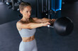 © ty - Image of attractive female doing kettle bell exercise in gym. Fitness woman working out. Crossfit exercise.