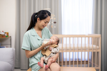 Canvas Print - Mom feed her newborn baby son with milk bottle at home