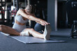 © ty - Young sporty woman stretching at the gym.