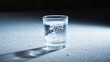© Andrey - Vodka shot on a sleek white surface with water droplets