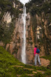 © Luis Herrera/Stocksy - woman traveller in front of a big waterfall in peru