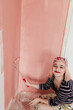 © Melika Tursic/Stocksy - Woman painting pink wall at home