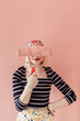 © Melika Tursic/Stocksy - portrait of a woman posing with pink brush and hiding her eyes