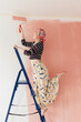 © Melika Tursic/Stocksy - Woman painting wall at home