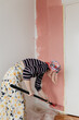 © Melika Tursic/Stocksy - Woman painting wall at home, first move
