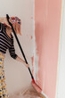 © Melika Tursic/Stocksy - Woman painting wall at home, first move
