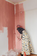 © Melika Tursic/Stocksy - Woman painting wall at home, first move