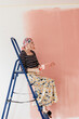 © Melika Tursic/Stocksy - Woman painting wall at home