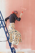 © Melika Tursic/Stocksy - Woman painting wall at home