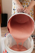 © Melika Tursic/Stocksy - close up of a Woman mixing colors for painting wall at home