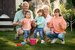 © Iuliia Versta/Stocksy - Granny and grandpa playing with their grandchildren on a backyard