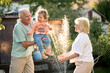 © Iuliia Versta/Stocksy - Grandparents playing with their granddaughter in the backyard