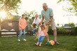 © Iuliia Versta/Stocksy - Grandparents playing their grandchildren on a backyard