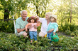 © Iuliia Versta/Stocksy - Portrait of a little children with their grandparents in the garden