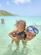 © Anya Brewley Schultheiss/Stocksy - Children playing together in crystal clear tropical ocean waves