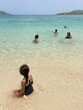 © Anya Brewley Schultheiss/Stocksy - Child with swim goggles holding on to her sister while she swims