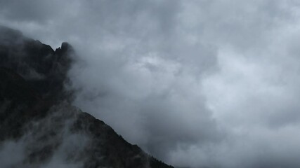 Wall Mural - time lapse of gray storm clouds blowing across a rocky mountain with distant trees