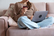 © Danil Nevsky/Stocksy - Woman using laptop and holding credit card is online shopping at home