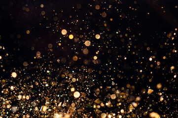 Wall Mural - sparkling golden particles create an enchanting effect against a dark background