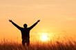 © jr-art - A man is standing in a field with his arms raised in the air