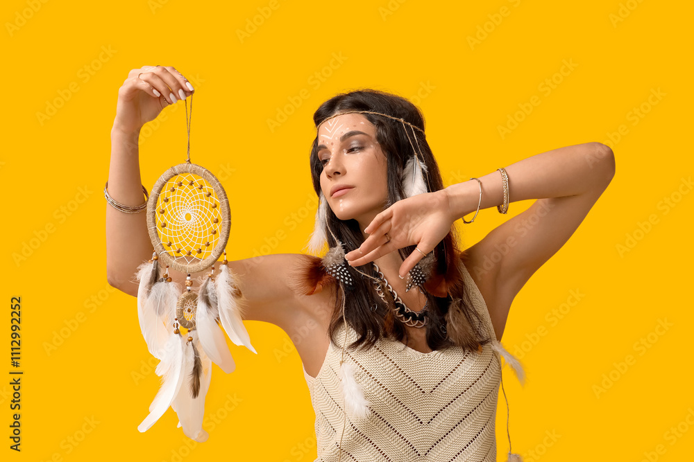 Beautiful female shaman with dream catcher on yellow background