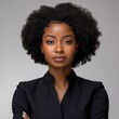 © Pete - Pro African American businesswoman with afro hairstyle. Black suit. Confident, focused expression. Studio portrait. Modern black businesswoman. Serious facial expression. Elegant business attire.