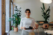 © BONNINSTUDIO/Stocksy - Waitress holding tray with cup of coffee in restaurant