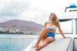 © Daniel - One young attractive girl enjoying summer days relaxed on catamaran in the ocean with turquoise water. Vacation lifestyle concept