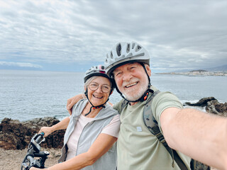 two happy old mature people enjoying and riding bikes together to be fit and healthy outdoors. activ