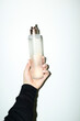 © Colour Laboratory/Stocksy - Hand holding clear liquid spray bottle with hard direct flashlight