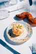 © Maria Sher/Stocksy - Elegant table setting with gourmet pastry and sesame bread twist