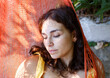 © Jimena Roquero/Stocksy - Woman lying on hammock in sunlight
