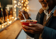 © Sandor - Senior man eating a bowl of warm chili at a christmas market