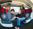 © Edward Córdoba / Andréas Sichel/Stocksy - Friends Playing in Smartphone While Traveling By Train