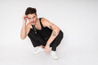 © mahalo studio/Stocksy - man with tattoos and mustache crouching posing in studio