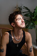 © mahalo studio/Stocksy - tattooed man sitting and enjoying sunlight at home