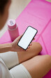 © mahalo studio/Stocksy - Woman holding smartphone with white screen after yoga session