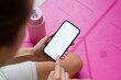 © mahalo studio/Stocksy - Woman using smartphone with white screen after fitness training