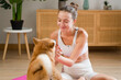 © mahalo studio/Stocksy - woman petting shiba inu dog while relaxing at home